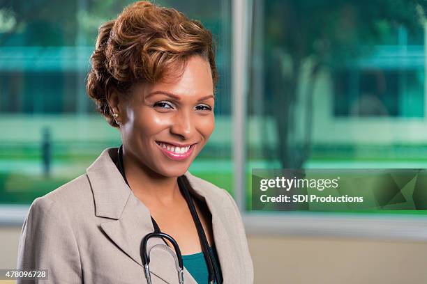 african american female doctor smiling in board room - auscultation woman stock pictures, royalty-free photos & images