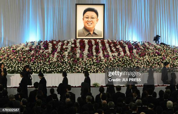Ethnic Koreans in Japan offer flowers on the altar for the late North Korean leader Kim Jong-Il during a memorial service at a Korean cultural centre...