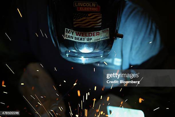 Worker welds a lawnmower frame together on the assembly line at the Dixie Chopper manufacturing facility in Coatesville, Indiana, U.S., on Friday,...