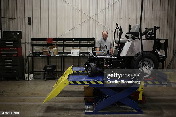 Worker inspects a completed lawnmower on the assembly line at the Dixie Chopper manufacturing facility in Coatesville, Indiana, U.S., on Friday, June...