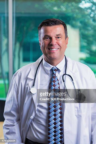 maduro médico de pé no hospital sala de conferência, vestindo bata de laboratório - male imagens e fotografias de stock