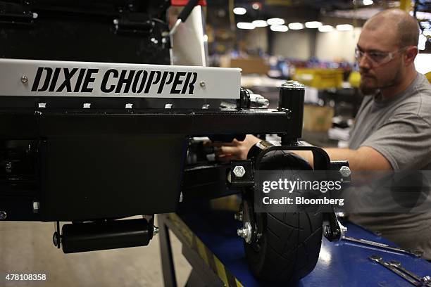 Worker puts the finishing touches on a completed lawnmower at the Dixie Chopper manufacturing facility in Coatesville, Indiana, U.S., on Friday, June...