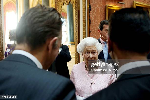 Queen Elizabeth II talks to guests at a reception at Buckingham Palace to celebrate The Queen's Young Leaders programme and present awards to the...