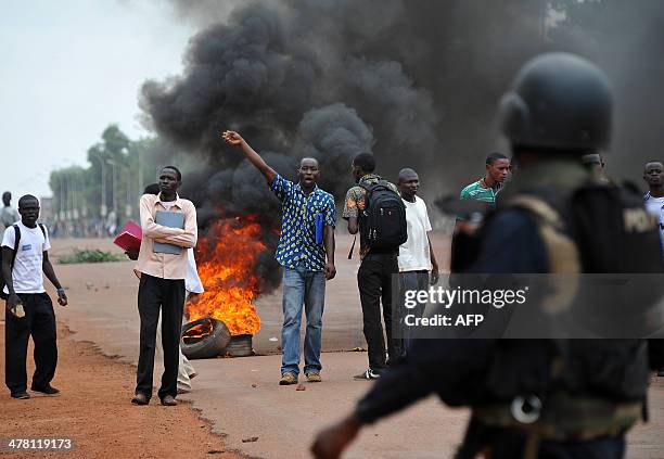 Student gestures as Congolese soldiers from Misca , Centrafrican Gendarmerie and police members patrol on March 12, 2014 in Bangui where students...