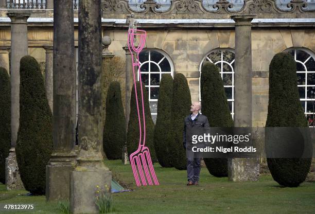 Man walks past Pinkfolk, by artist Michael Craig-Martin, which is part of a new exhibition of his work at Chatsworth House on March 12, 2014 in...