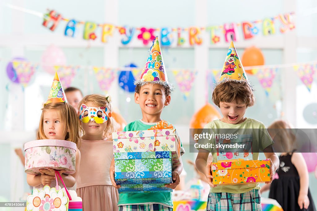 Cheerful group of children holding birthday presents.