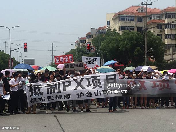 Demonstrators hold banners with slogans to protest against a paraxylene project in Jinshan district in Shanghai on June 23, 2015. Several hundreds of...