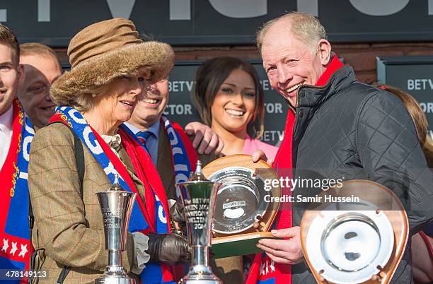 Camilla, Duchess of Cornwall present a trophy to Gary Moore, trainer of Sire De Grugy, the winning horse in Queen Mother Champion Chase during The...