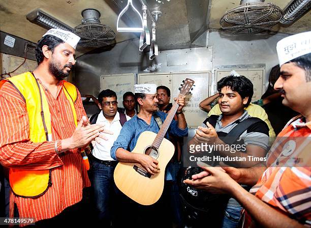 Supporters of Aam Aadmi Party Chief Arvind Kejriwal sing during his travel in a local train from Andheri Station to Churchgate Railway Station on...