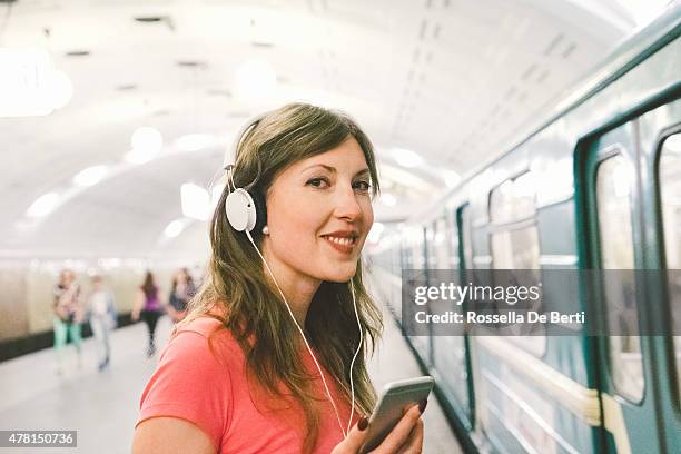 beautiful woman listening music on her smartphone, subway train background - walkman closeup stock pictures, royalty-free photos & images