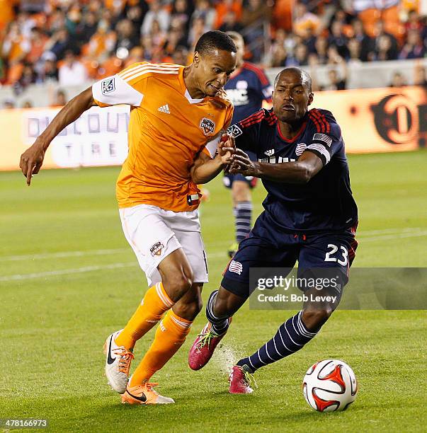 Ricardo Clark of Houston Dynamo attempts to get past Jose Goncalves of New England Revolution at BBVA Compass Stadium on March 8, 2014 in Houston,...