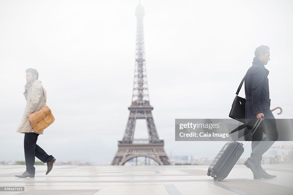 Business people walking past Eiffel Tower, Paris, France