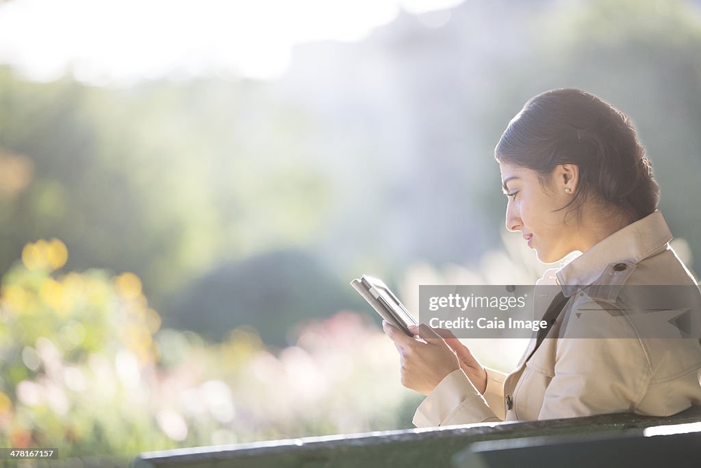 Businesswoman using digital tablet in park