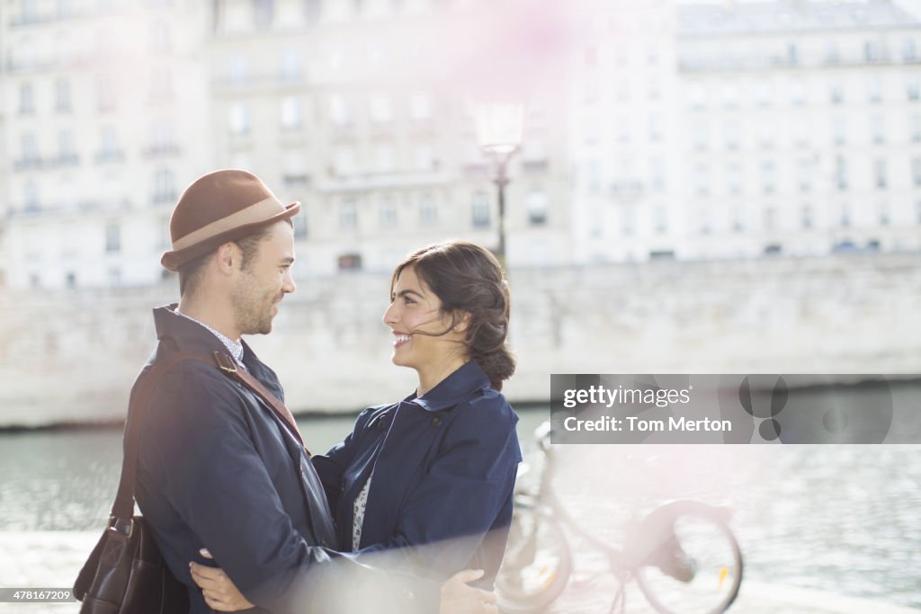 Couple hugging along Seine River, Paris, France