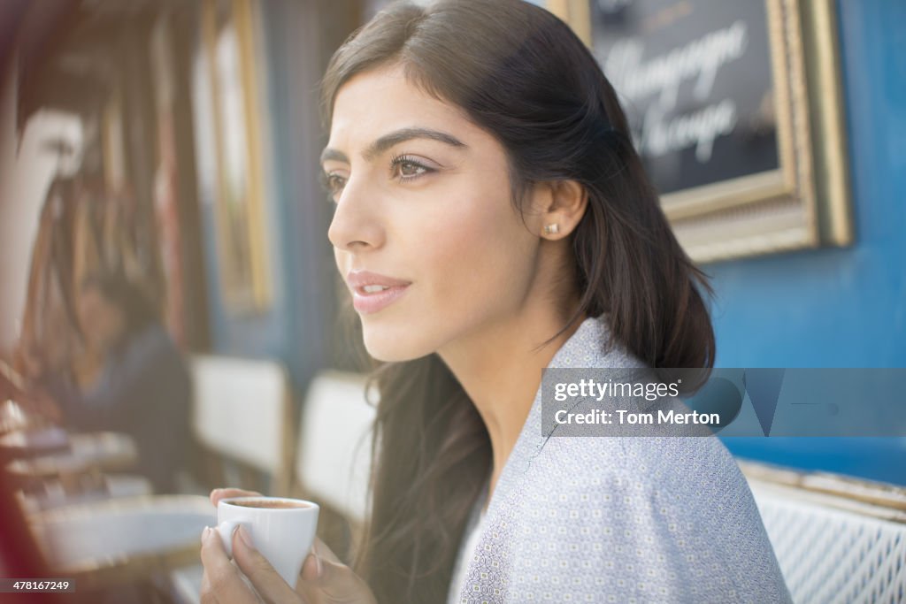 Mulher beber café no Café Esplanada