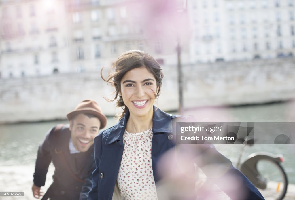Couple laughing and running along Seine River, Paris, France