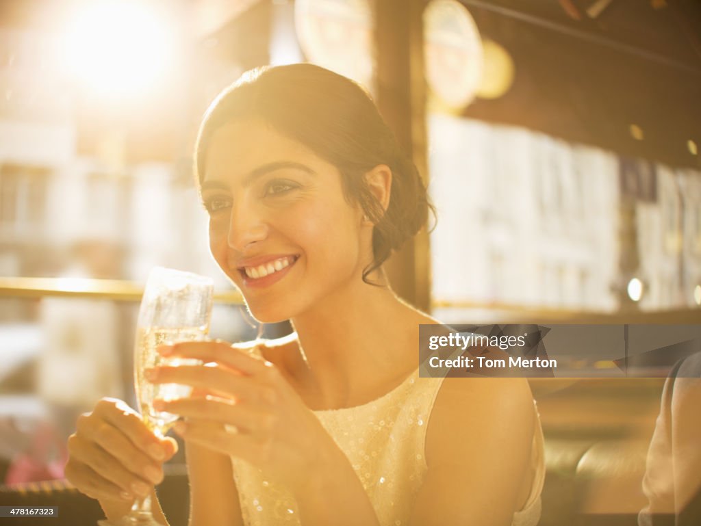 Well-dressed woman drinking champagne in restaurant