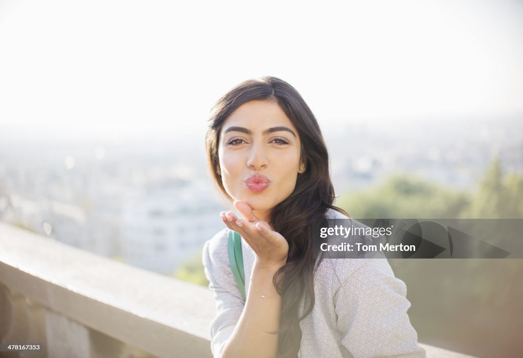 Woman blowing a kiss outdoors