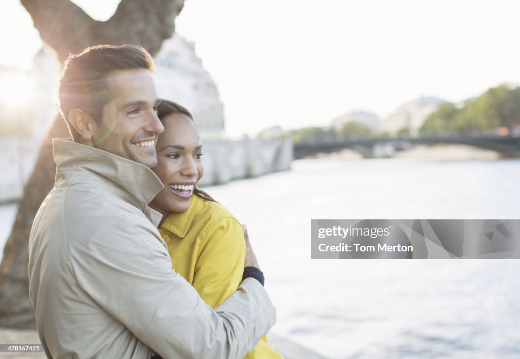 Coppia abbracciare lungo il fiume Senna, Parigi, Francia