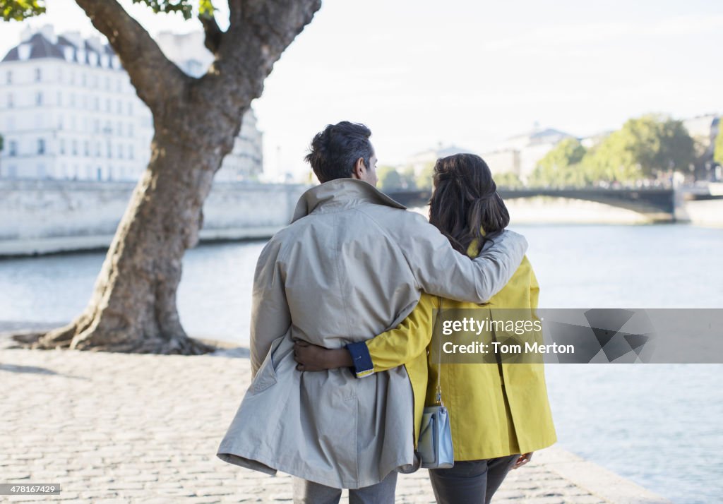 Couple walking along Seine River, Paris, France