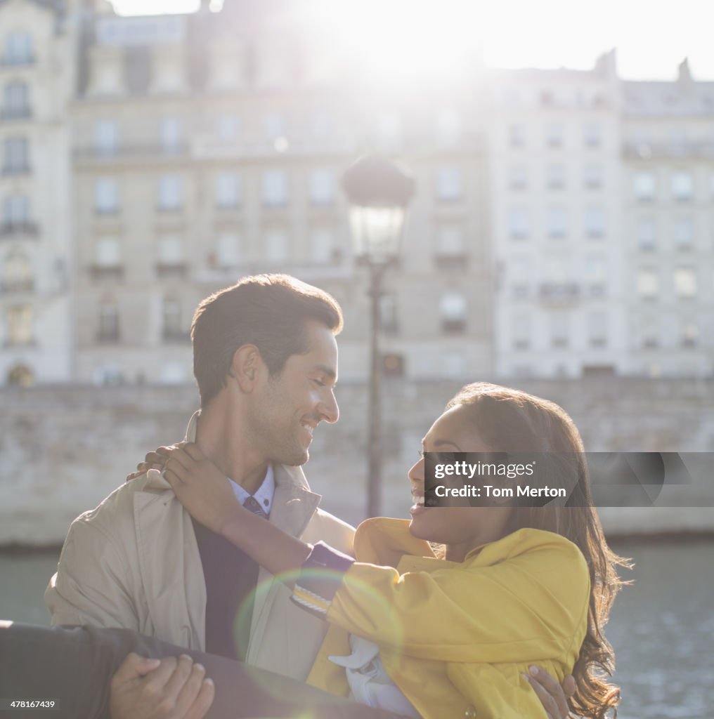 Man holding girlfriend along Seine River, Paris, France