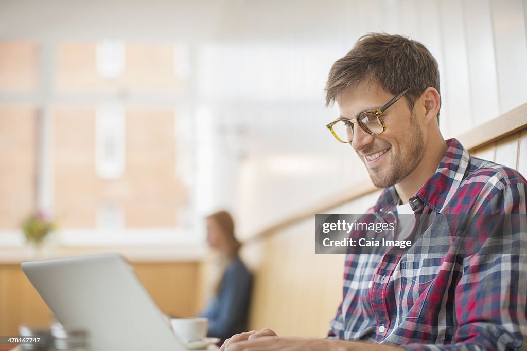 Man using laptop in cafe