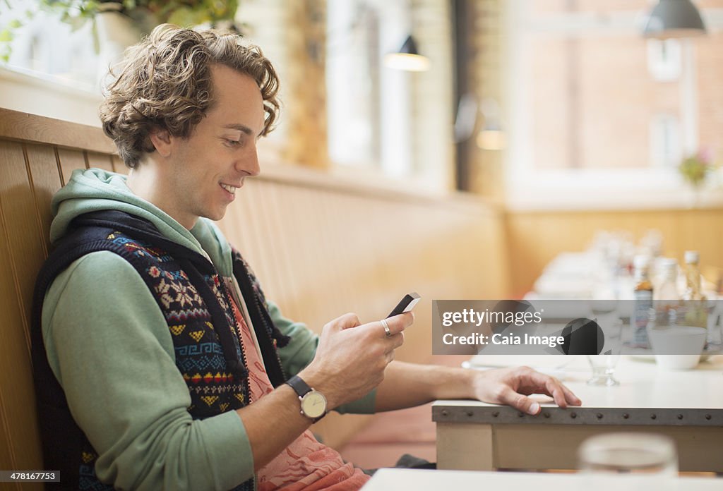 Mann mit Handy im Café