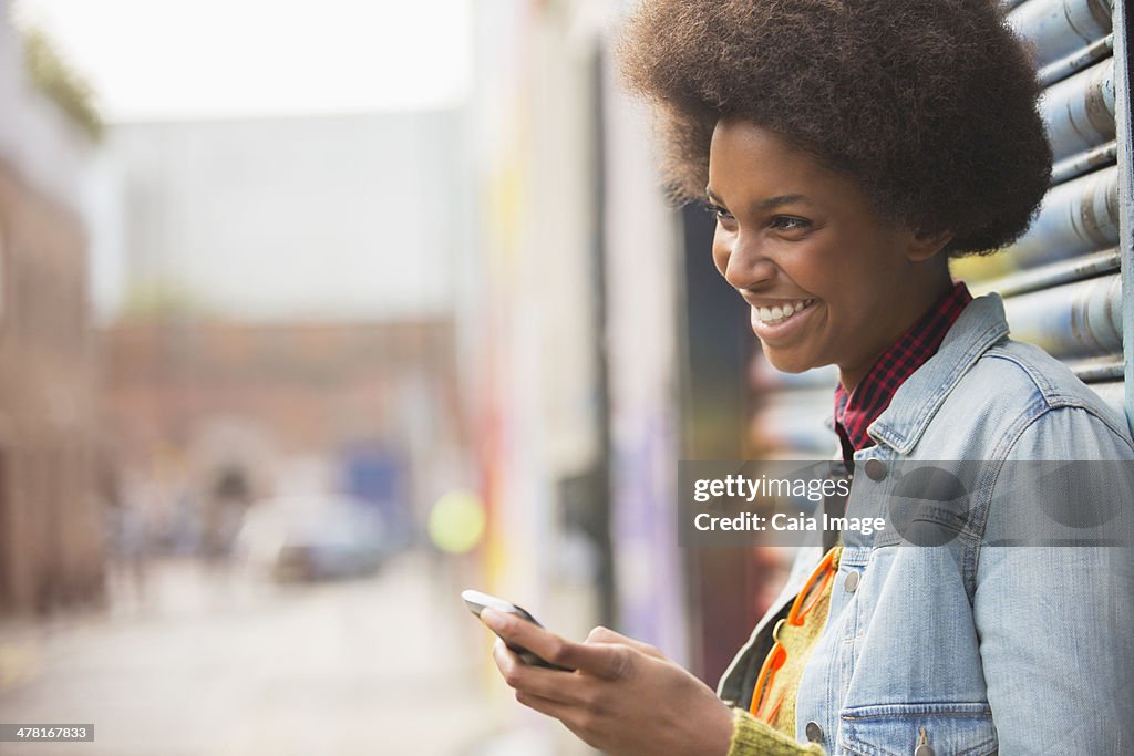 Woman using cell phone on city street