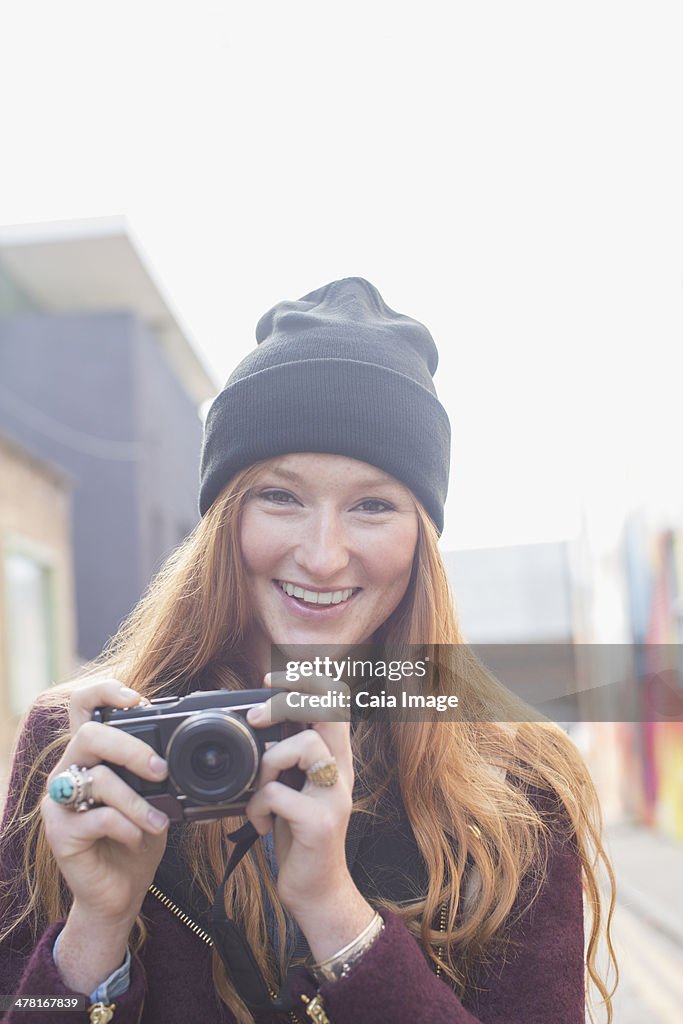 Woman using camera on city street