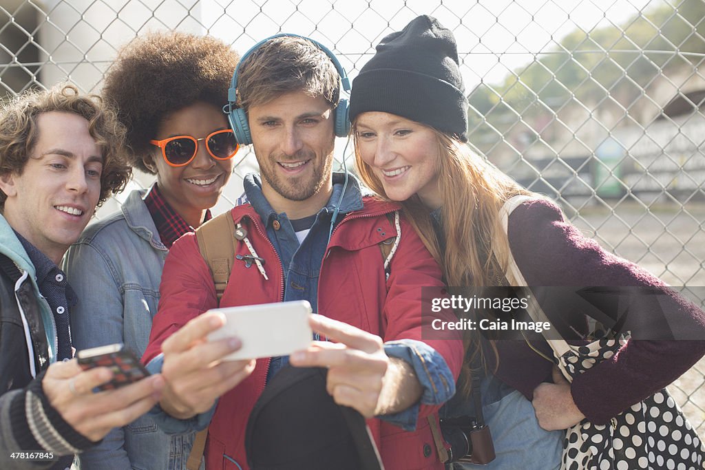 Friends taking self-portrait with camera phone outdoors