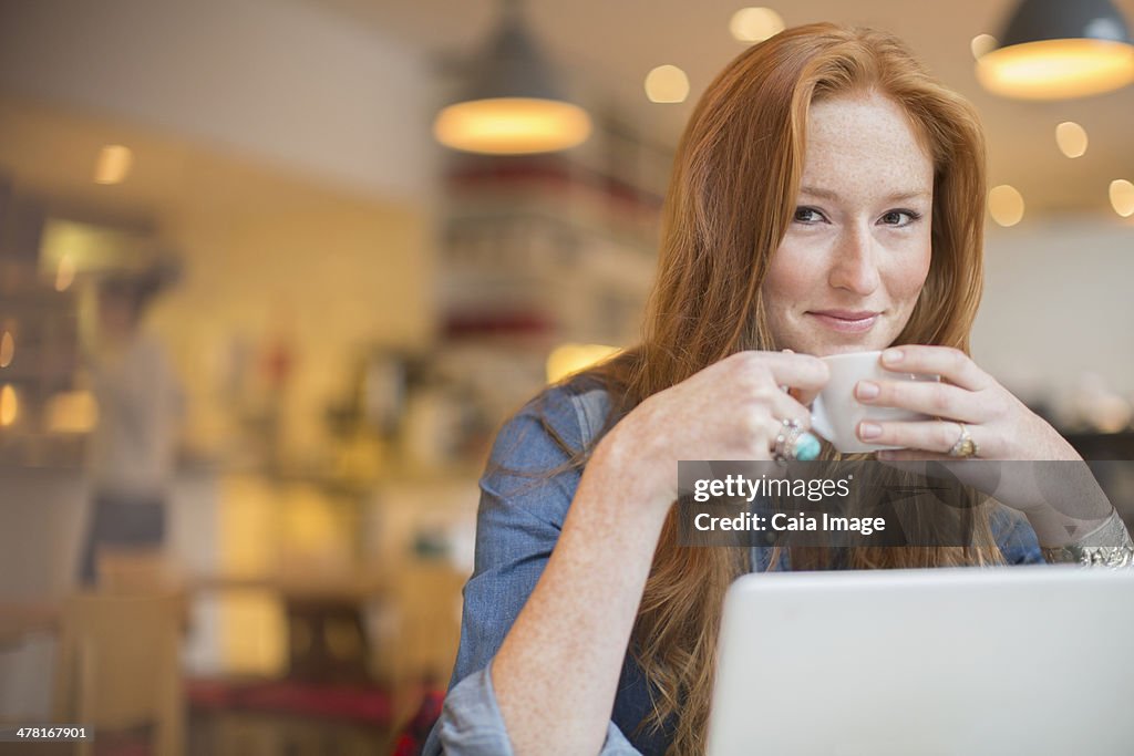 Woman using laptop in cafe