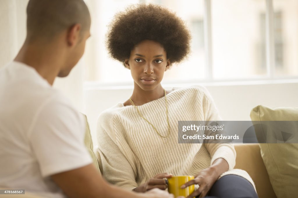 Couple drinking coffee on sofa