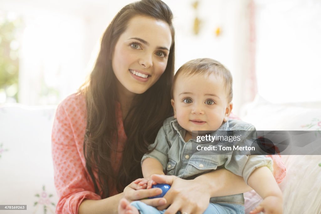 Mère tenant bébé garçon sur un canapé