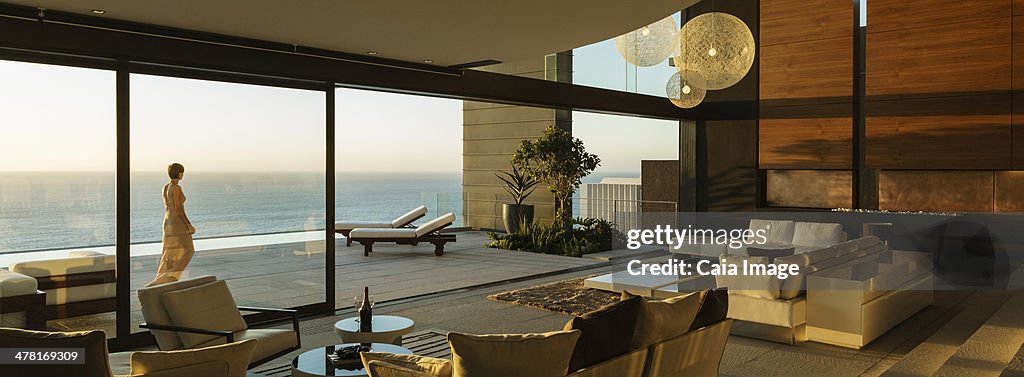 Woman walking on modern patio overlooking ocean