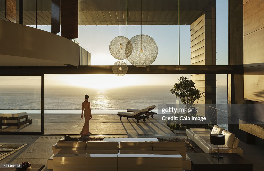 Mulher em casa moderna com vista para Oceano