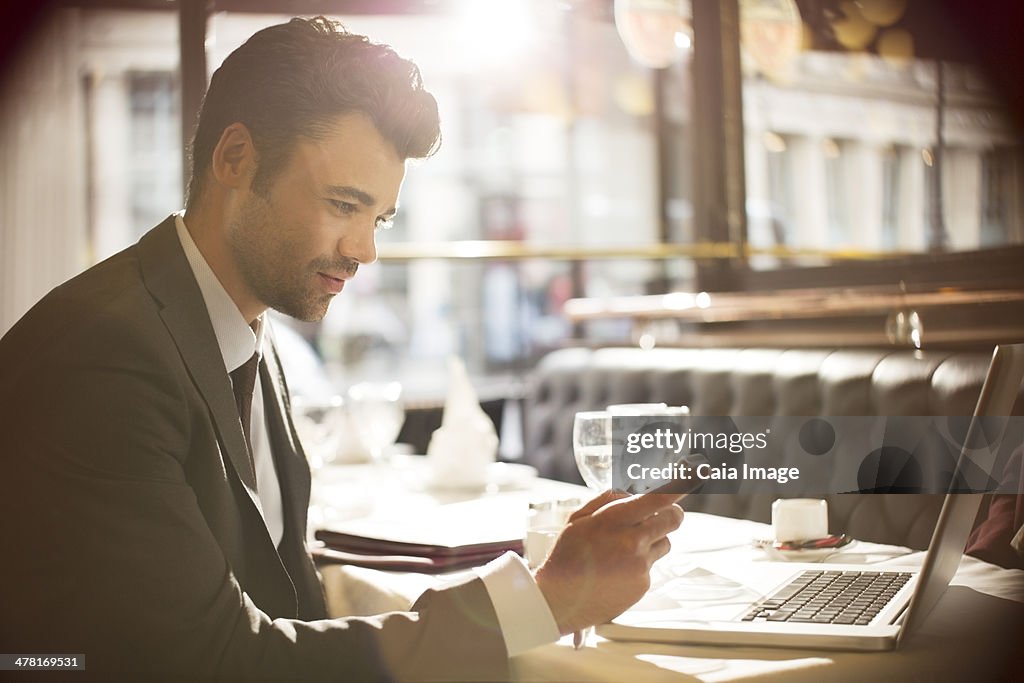Homem de negócios com computador portátil no restaurante