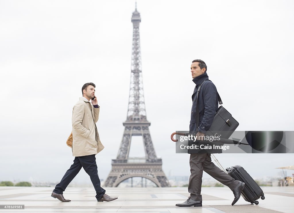 Businessmen walking past Eiffel Tower, Paris, France