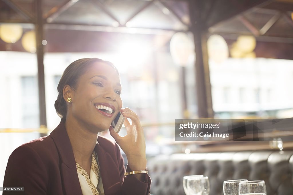 Mulher de Negócios fala no telefone celular no restaurante