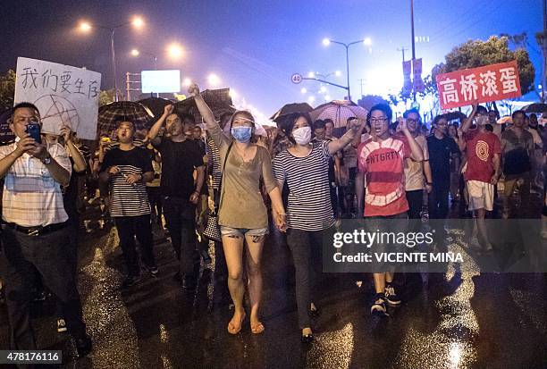 Demonstrators hold banners with slogans to protest against a paraxylene project in Jinshan district in Shanghai on June 23, 2015. Several hundreds of...