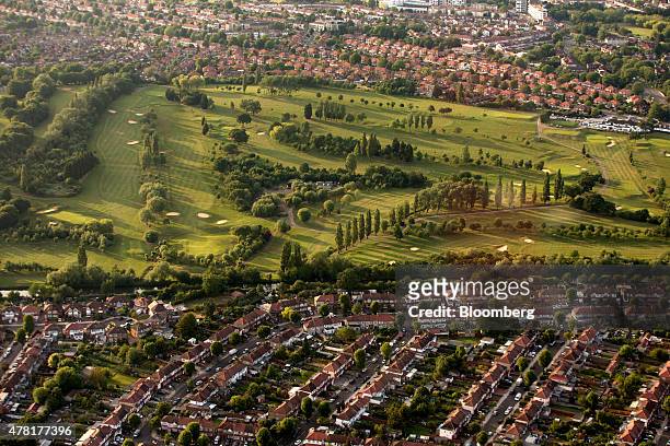 The greens and sand bunkers on Perivale Park golf course are surrounded by rows of residential housing in this aerial photograph taken over...
