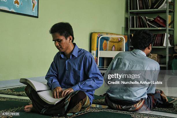 People blind reads a Braille Quran at a blind foundation on June 23, 2015 in Tangerang, Indonesia. Braille Quran is the translation of Quran verses...