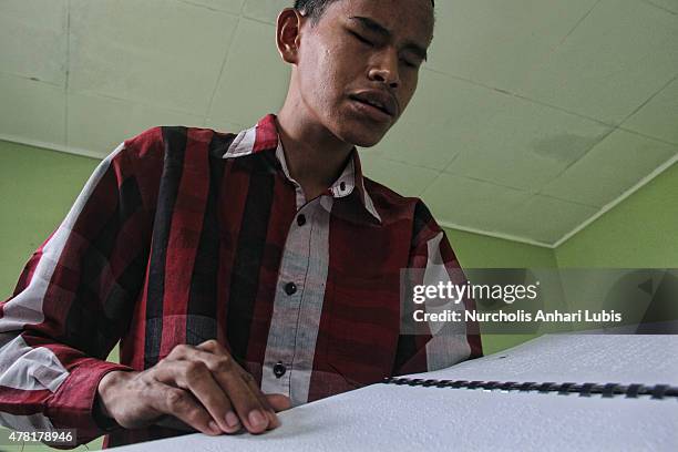 Blind reads a Braille Quran at a blind foundation on June 23, 2015 in Tangerang, Indonesia. Braille Quran is the translation of Quran verses to...