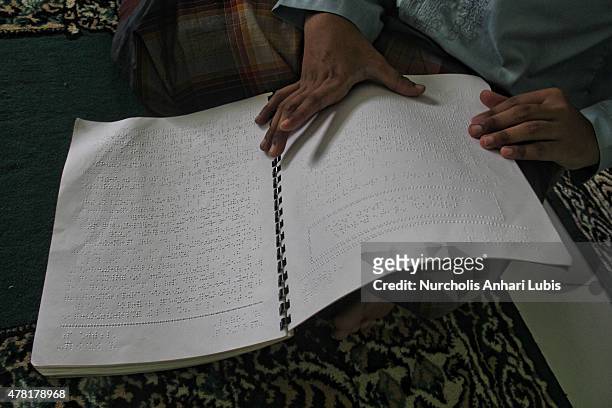 Blind reads a Braille Quran at a blind foundation on June 23, 2015 in Tangerang, Indonesia. Braille Quran is the translation of Quran verses to...