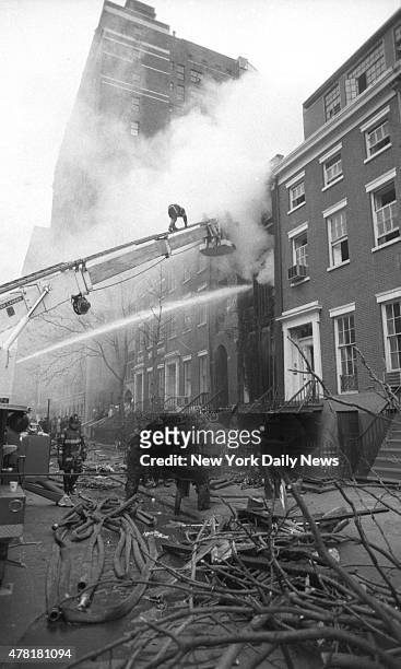 Firemen on cherry picker close in on the steaming ruin of the devastated house. Greenwich Village townhouse is a pile of smoldering rubble after...