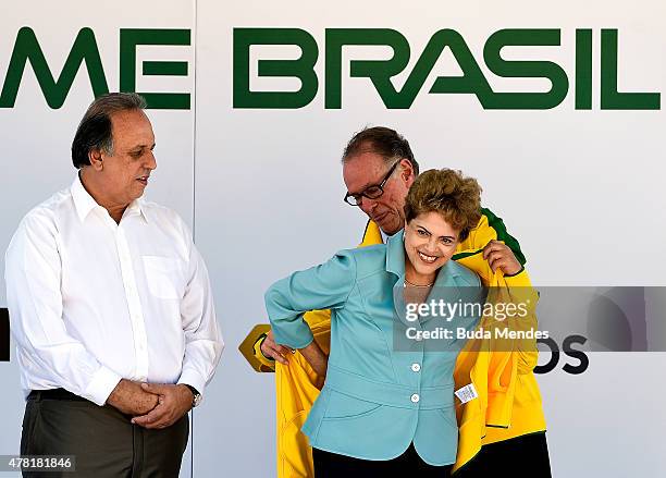 The president of the Brazilian Olympic Committee, Carlos Arthur Nuzman, puts a national team jacket on President Dilma Rousseff of Brazil after the...