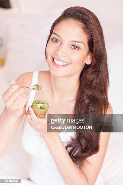 woman eating fruit - kiwi foto e immagini stock