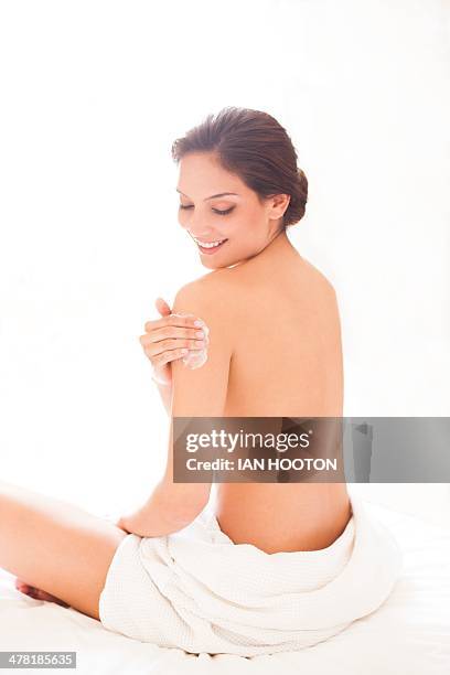 woman applying body lotion - crema corporal fotografías e imágenes de stock