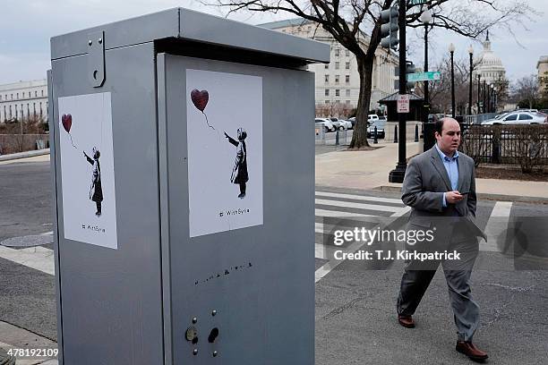 Poster with graffiti artist Banksy's girl with a red balloon deisgn is pasted to a utility box near the U.S. Capitol on March 12, 2014 in Washington,...