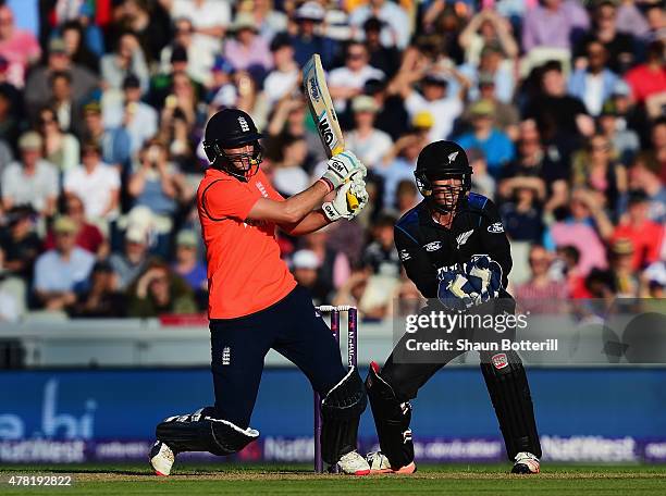 Joe Root of England plays a shot as Luke Ronchi of New Zealand looks on during the NatWest International Twenty20 match between England and New...