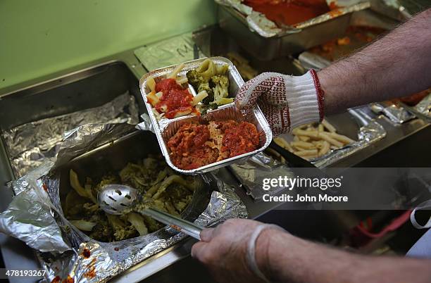Catholic Services worker prepares "meals on wheels" lunch delivery on March 12, 2014 in Franklin, New Jersey. This year's harsh winter has left many...